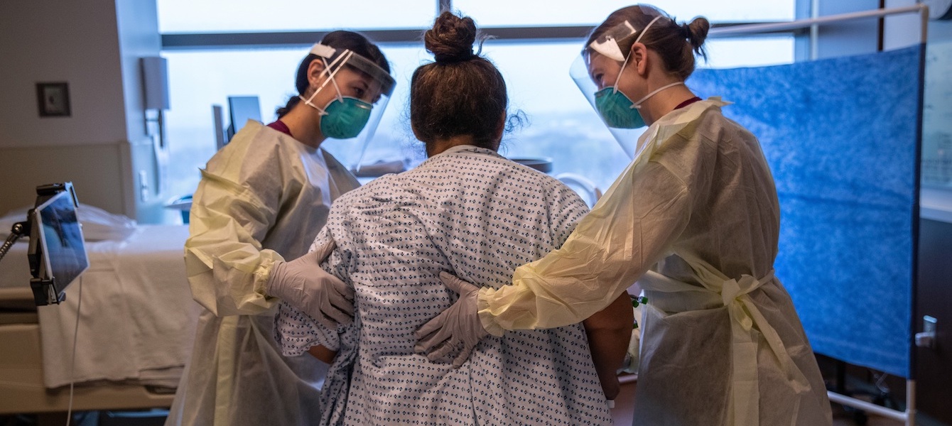 STAMFORD, CONNECTICUT - APRIL 24: (EDITORIAL USE ONLY) Hospital workers help COVID-19 patient and Guatemalan asylum seeker Zully to take her first steps after being removed from a ventilator at a Stamford Hospital ICU on April 24, 2020 in Stamford, Connecticut. Weeks after giving birth to her son Neysel through an emergency C-section and put on a ventilator, Zully took part in a plasma antibodies trial, which has shown dramatic early results, according to hospital officials. Zully, still positive for coronavirus, has yet to hold her baby, who is healthy and temporarily staying with her son's teacher Luciana Lira. The K-5 Bilingual /ESL instructor at Hart Magnet Elementary School continues remote teaching her elementary school students, while also caring for the infant at home. She plans to continue as the baby's temporary custodian until the entire Guatemalan family, including Zully, the child's father Marvin and their son Junior, 7, also recover and test negative for the virus.  (Photo by John Moore/Getty Images)
