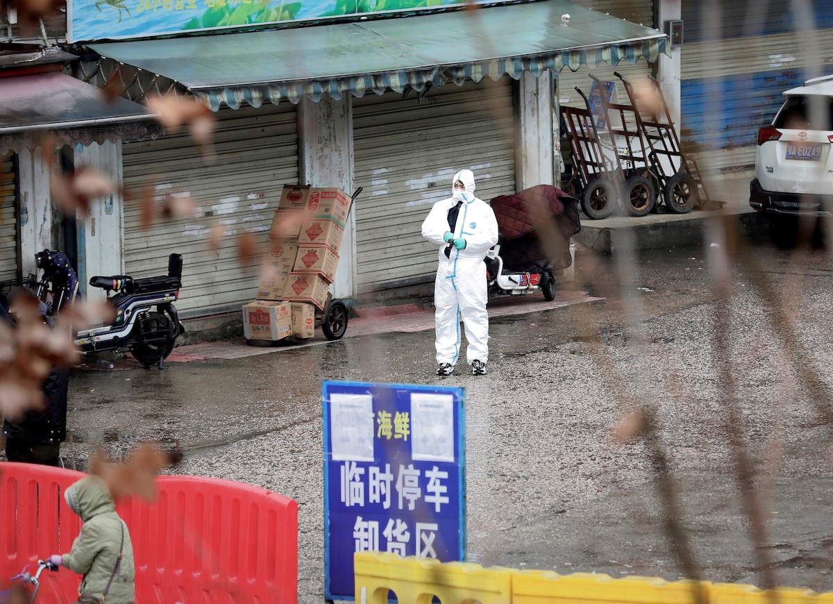 A worker in a protective suit is seen at the closed seafood market in Wuhan, Hubei province, China January 10, 2020. The seafood market is linked to the outbreak of the pneumonia caused by the new strain of coronavirus, but some patients diagnosed with the new coronavirus deny exposure to this market. Picture taken January 10, 2020. REUTERS/Stringer CHINA OUT.     TPX IMAGES OF THE DAY - RC2QJE9UWB3Q
