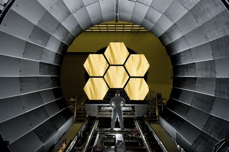 ERNIE WRIGHT STANDS NEAR THE JAMES WEBB SPACE TELESCOPE MIRRORS AS THEY SIT JUST OUTSIDE THE TESTING CHAMBER IN THE XRAY CALIBRATION FACILITY AT MSFC